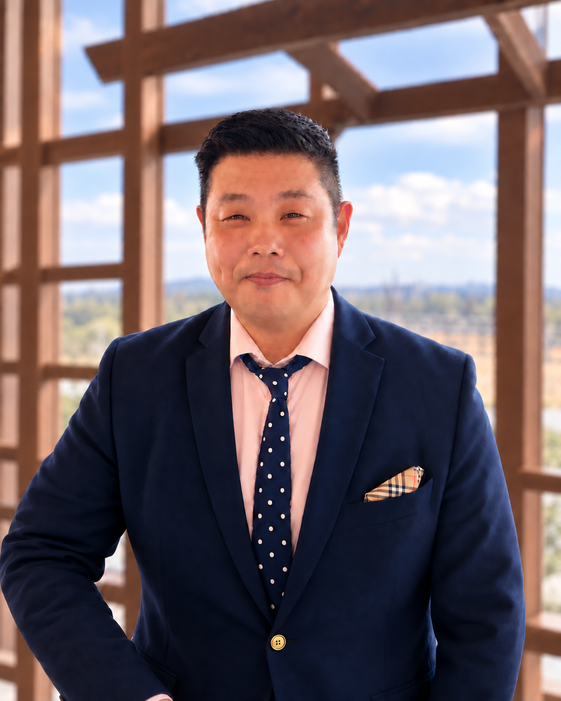 Portrait of Dr. Sam D. Kim in a navy suit by a window